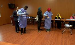 Sudanese healthcare professionals put on personal protection equipment during a training workshop 