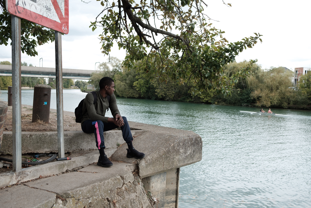 Yannick sits by a canal, close to MSF's Passerelle project in Paris  © Augustin Le Gall