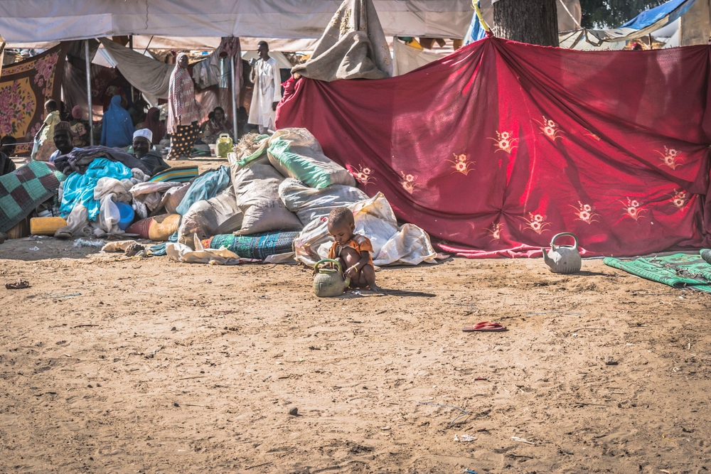 A child playing with a water pot in an  IDP camp in Monguno [ © Maro Verli/MSF ]