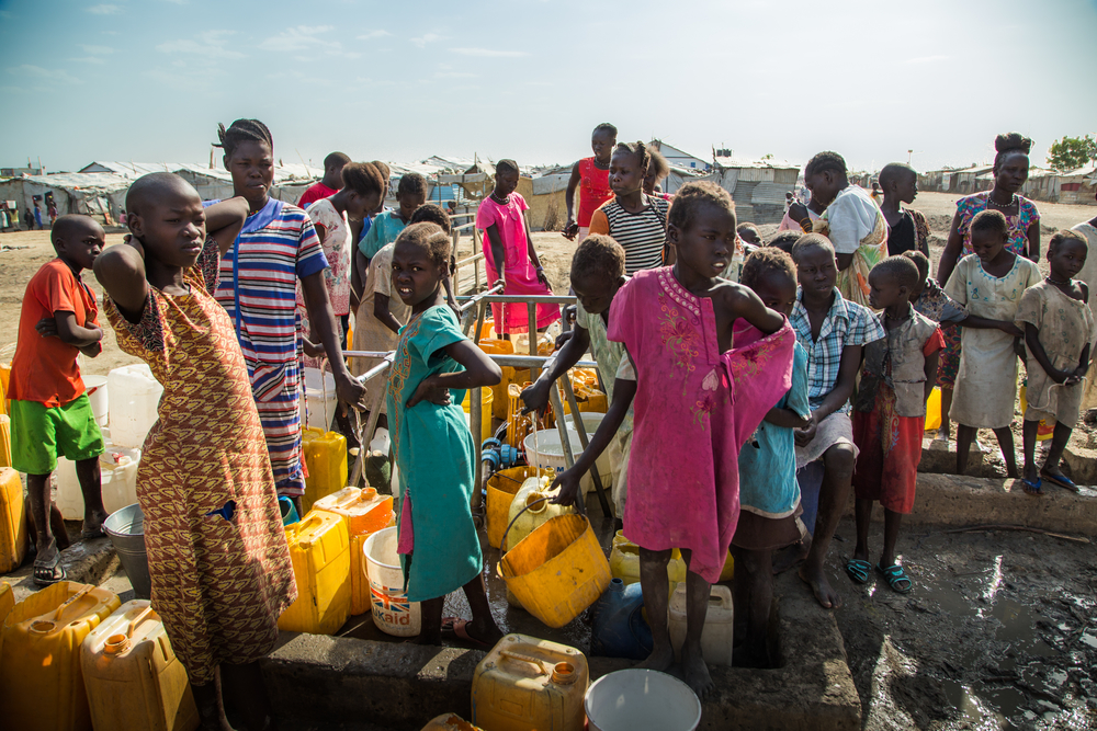 Women and children queue at a water point in the Malakal Protection of Civilian (PoC) site, in north-east South Sudan, where over 29,000 internally displaced people continue to live today. [ MSF/ Igor Garcia]