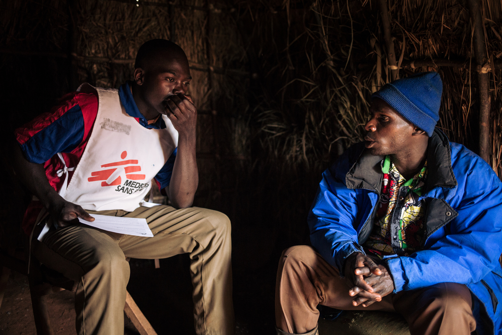 Djapan speaks to Dieudonné Ngandru Lossi. in his straw shelter at the Rho IDP site in Ituri
