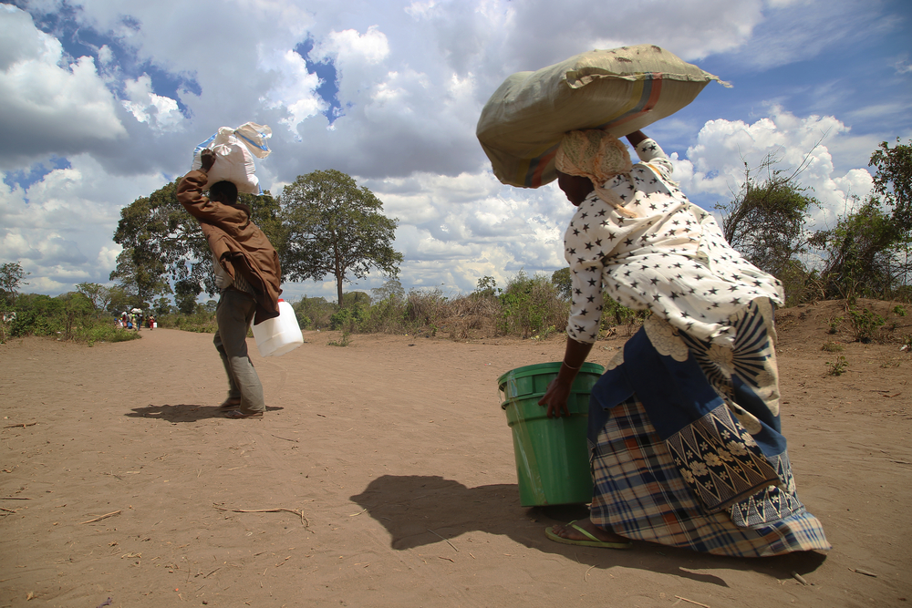 A man and woman carry a set of relief items distributed by an MSF team 