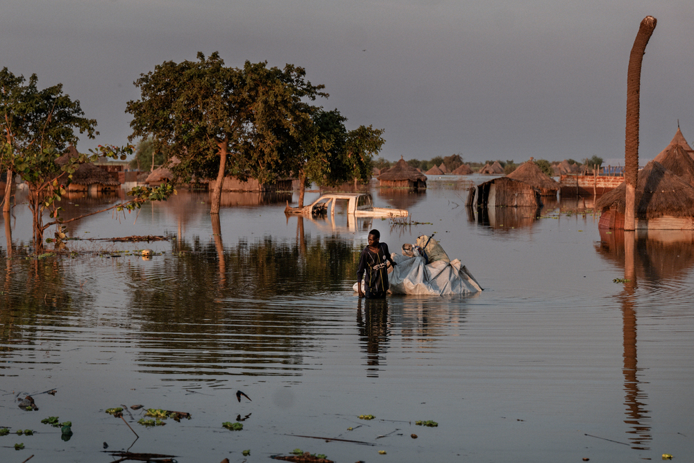 A man drags a tarpaulin raft through the flood in Rubkona, Unity State. ©  Sean Sutton 