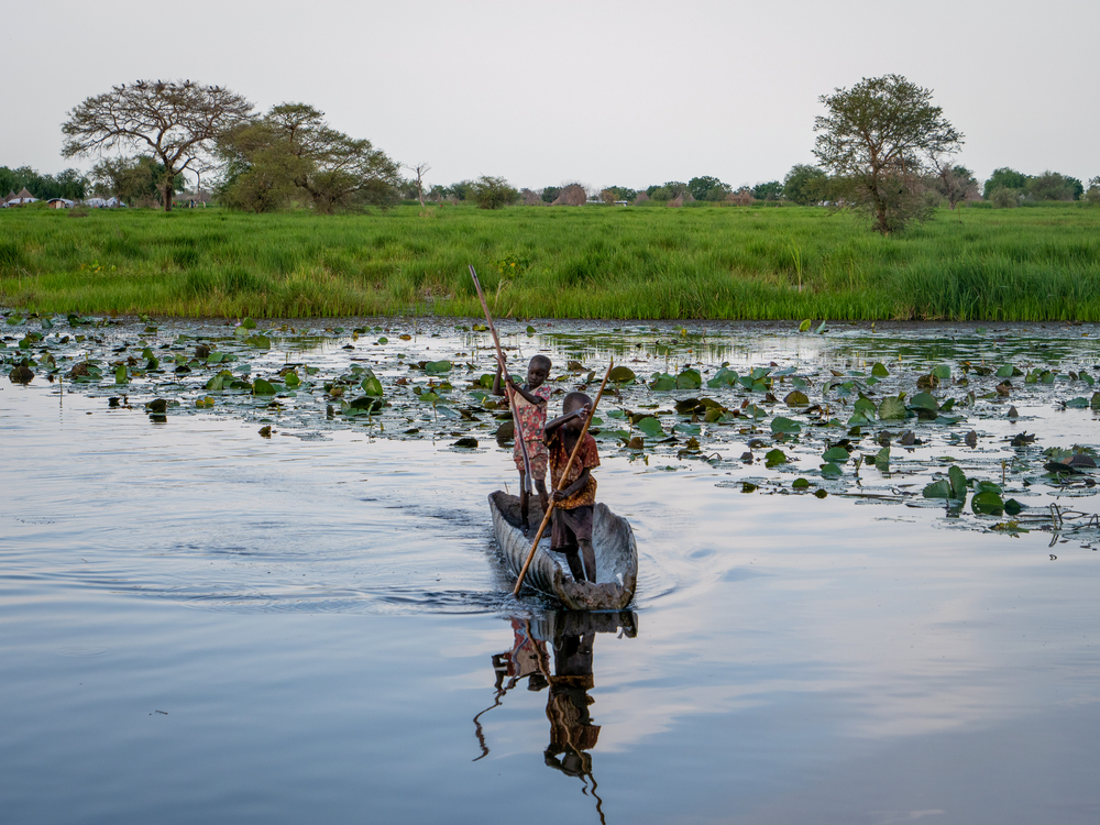 Young boys steer a canoe in Old Fangak, South Sudan. [© Florence Miettaux]