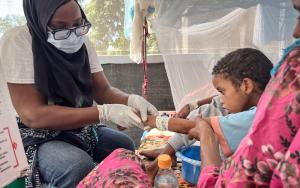 An 11-year-old boy recovering from diphtheria in a treatment unit at Ati Hospital in Chad, lying weak on a hospital bed.