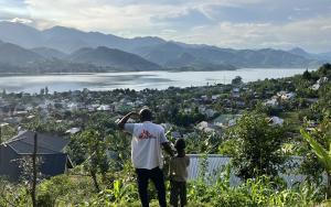 An MSF staff member and a child look at the town of Minova and Lake Kivu from the top of a hill. South Kivu province, eastern DRC