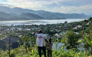 An MSF staff member and a child look at the town of Minova and Lake Kivu from the top of a hill. South Kivu province, eastern DRC