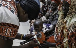 Malnutrition screening of one-year-old Alnel on the knees of his mother Nyanbeny. Ameth Bek Hospital, Abyei.