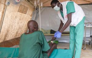 A Médecins Sans FrontièreMSF clinician treating a cholera patient inside the cholera treatment centre in Abyei during the outbreak response.s (MSF) clinician provides medical care to a cholera patient at MSF’s treatment centre in Abyei, as part of the emergency response to the ongoing outbreak.
