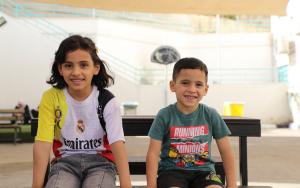 Omar sits with his sister in the playground at the reconstructive surgery hospital in Amman, Jordan. Omar was injured in an Israeli strike, after a piece of shrapnel tore through his leg.