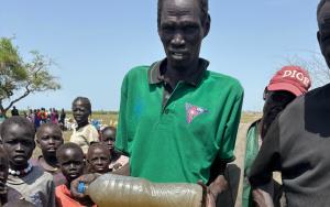 South Sudanese refugees in Ethiopia’s Gambella region collecting water from a contaminated source, highlighting the lack of sanitation and clean water access in the area.
