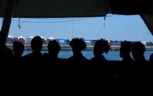 Survivors from Geo Barents disembark in Bari after days at sea; rescue team brings bodies of two deceased young women ashore.