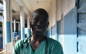 Community Health Officer Claude Ndoko standing outside the paediatrics unit of Magburaka government hospital, supported by MSF, in Tonkolili district, Sierra Leone.