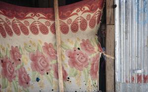A man looks out from a shelter in the market zone in Bentiu PoC (Protection of Civilians) site. [ © Emin Ozmen/Magnum Photos ] 