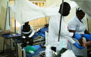 A man who is recovering from his burns sits on his bed in the burn unit ward. [© Benedicte Kurzen/NOOR]