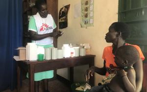 MSF Nursing Care Provider Abau Susan issues medication & explains its use to a mother