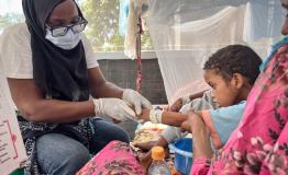 An 11-year-old boy recovering from diphtheria in a treatment unit at Ati Hospital in Chad, lying weak on a hospital bed.