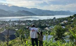 An MSF staff member and a child look at the town of Minova and Lake Kivu from the top of a hill. South Kivu province, eastern DRC