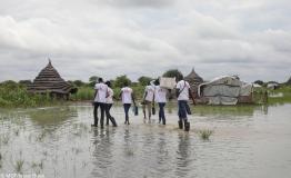MSF teams wade through a flooded village to deliver medicine to an ICCM site in Abyei.