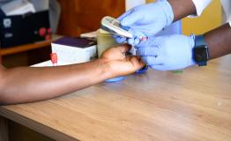 Close up of patient advocate Pamela Anyango undergoing a blood sugar test