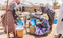 Women collecting water at a distribution point in Alacha camp, eastern Chad.