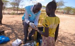David Ekeru, a community health promoter, tests a child for malaria at their home using the test and treat approach in Namakane village, Turkana, Kenya.