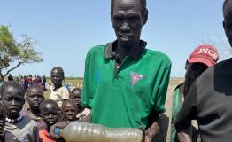 South Sudanese refugees in Ethiopia’s Gambella region collecting water from a contaminated source, highlighting the lack of sanitation and clean water access in the area.