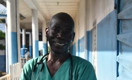 Community Health Officer Claude Ndoko standing outside the paediatrics unit of Magburaka government hospital, supported by MSF, in Tonkolili district, Sierra Leone.