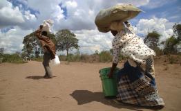 A man and woman carry a set of relief items distributed by an MSF team 