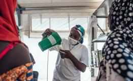 Safaratu Tambaya, nutrition support officer, pours therapeutic milk into containers for patients at 