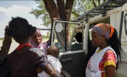 Zeitun Yussuf(centre) and Fiona Mutindwa (right) speak to a mother during an outreach in Illeret