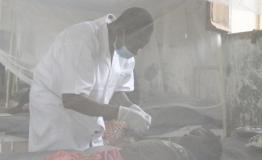 A nurse at the Bosobolo General Referral Hospital cares for a young patient with measles