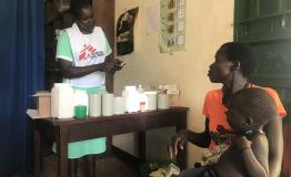 MSF Nursing Care Provider Abau Susan issues medication & explains its use to a mother