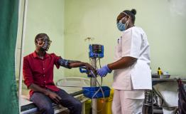 Faith Njeri, an EMT at MSF Lavender House checks vitals of a patient