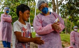 Nurse Nara Duarte teaches a child the correct way to perform hand hygiene 