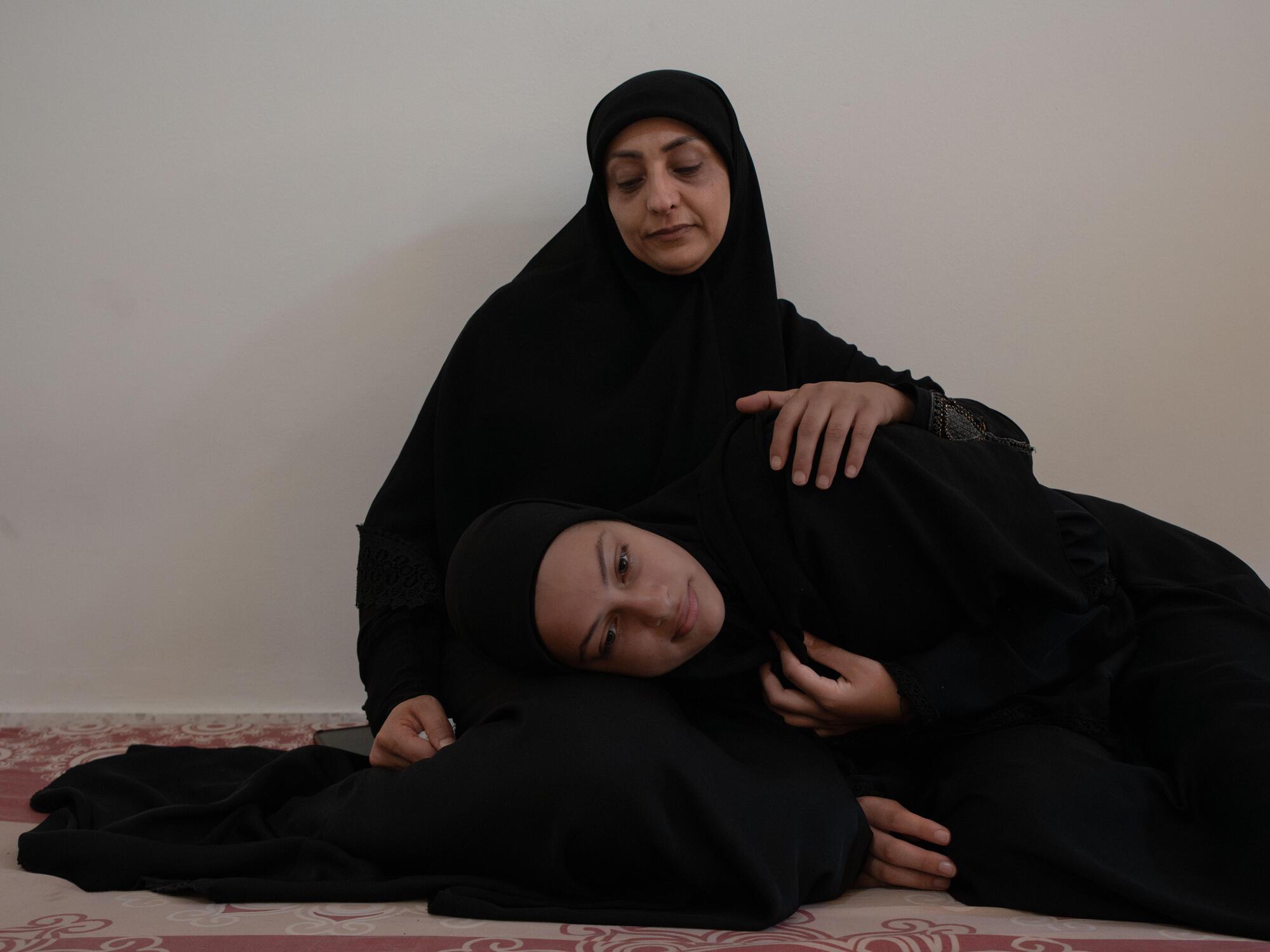 Ezdihar al Diqa with her daughter, Nouraya, in the room they have been sharing with 14 other people at Azariye camp
