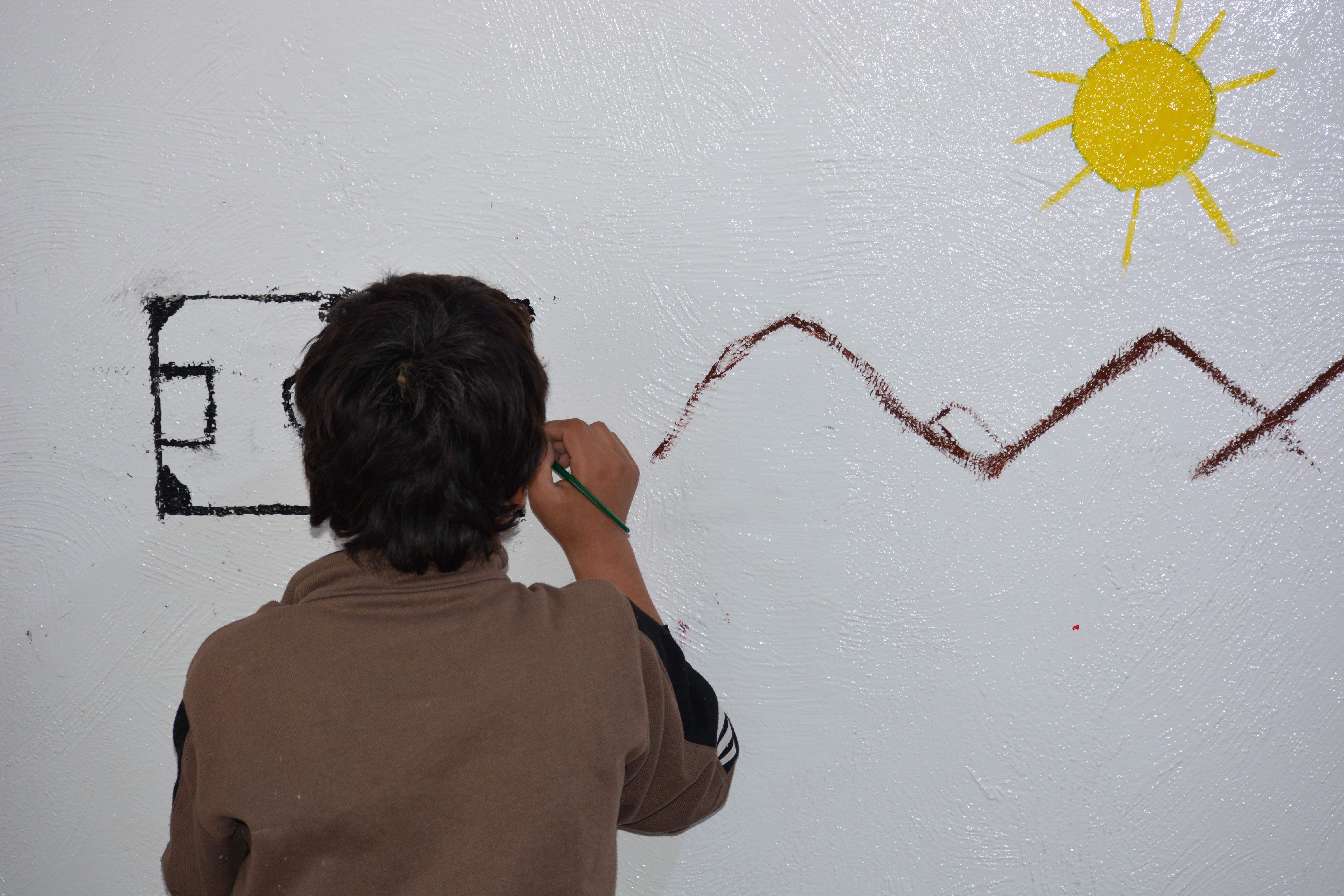 A teenager draws on the wall at MSF’s mental health clinic in Al-Hol camp, northeast Syria, 13 December 2023.