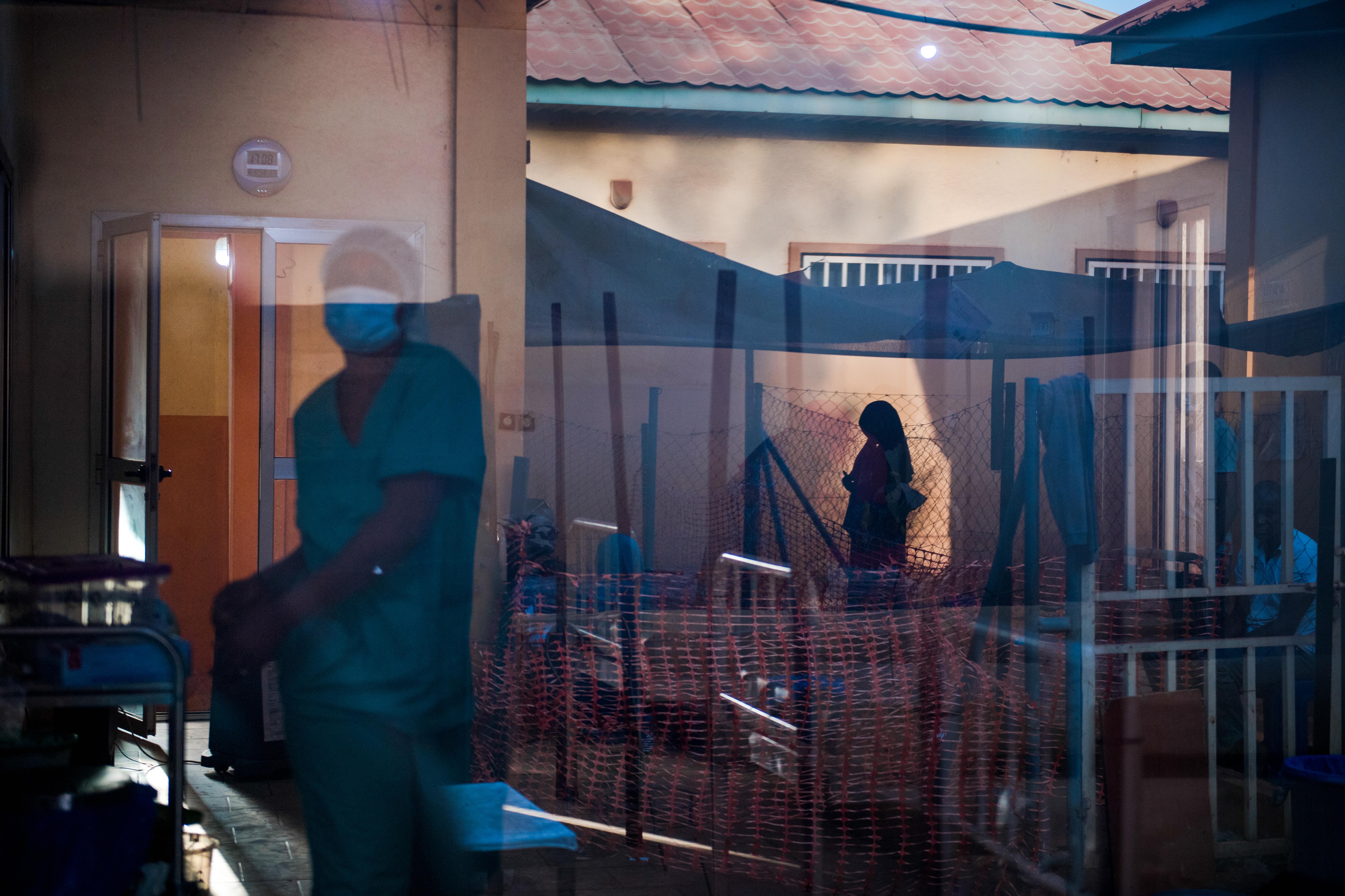 A nurse walks among patients at the Centre de Traitement Epidemiologique in Siguiri, Guinea.