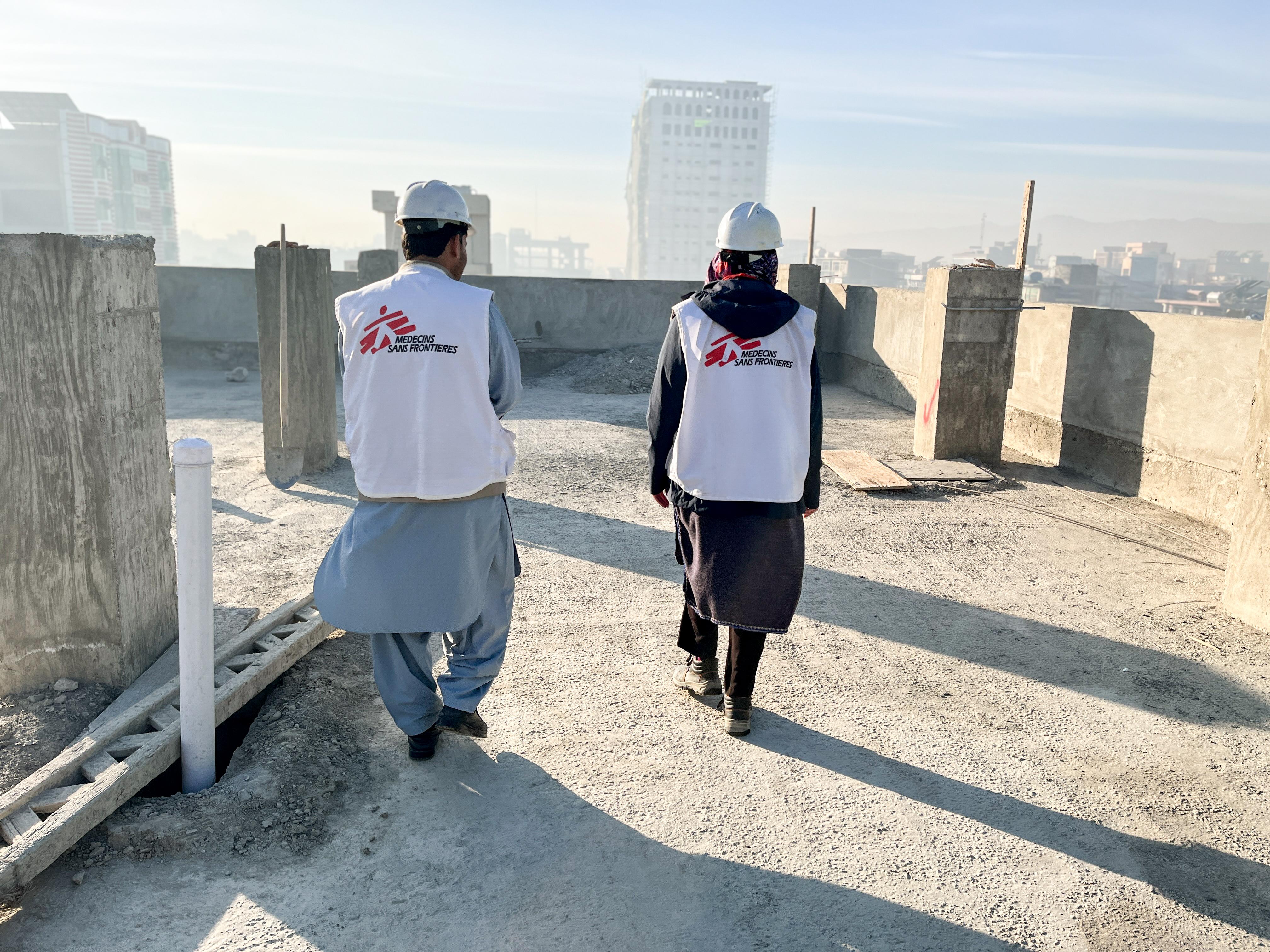 The MSF construction team walk on the roof of a new building under construction in the Khost maternity hospital compound.