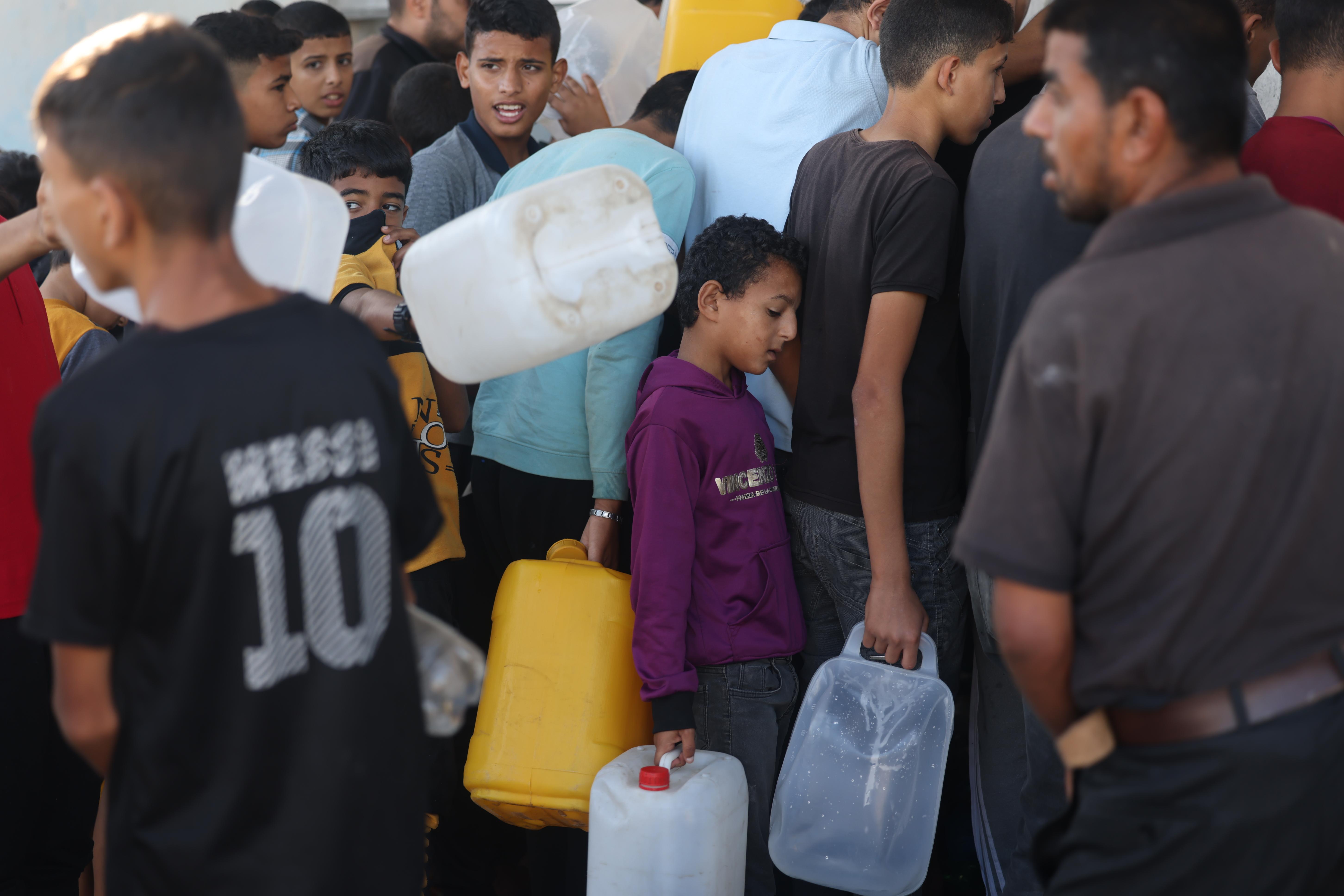 Displaced Palestinians line up for water in Kahn Younis, after arrivingfrom Rafah.