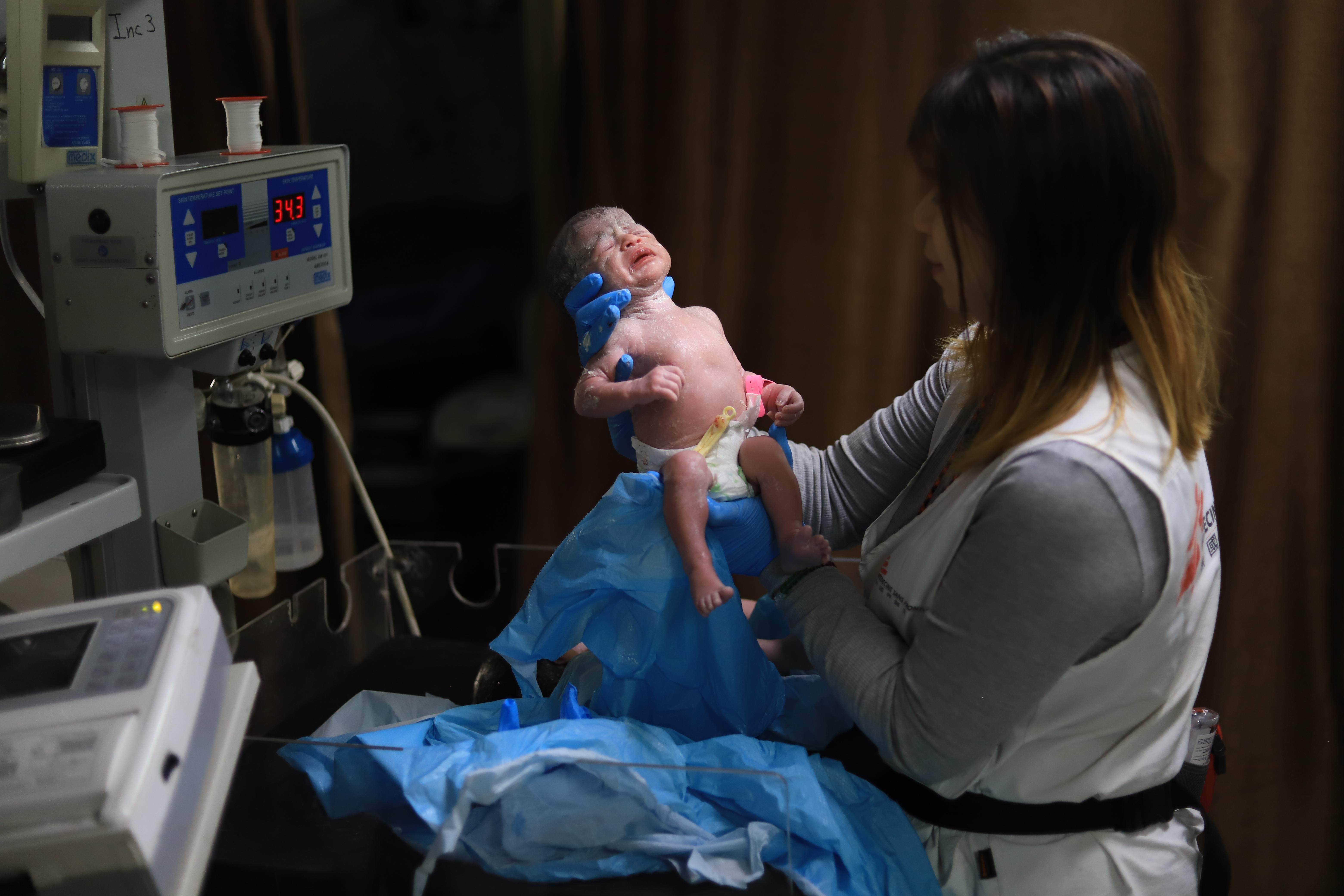 Hin So, MSF midwife activity manager, checks on a newborn baby at Nasser hospital, southern Gaza