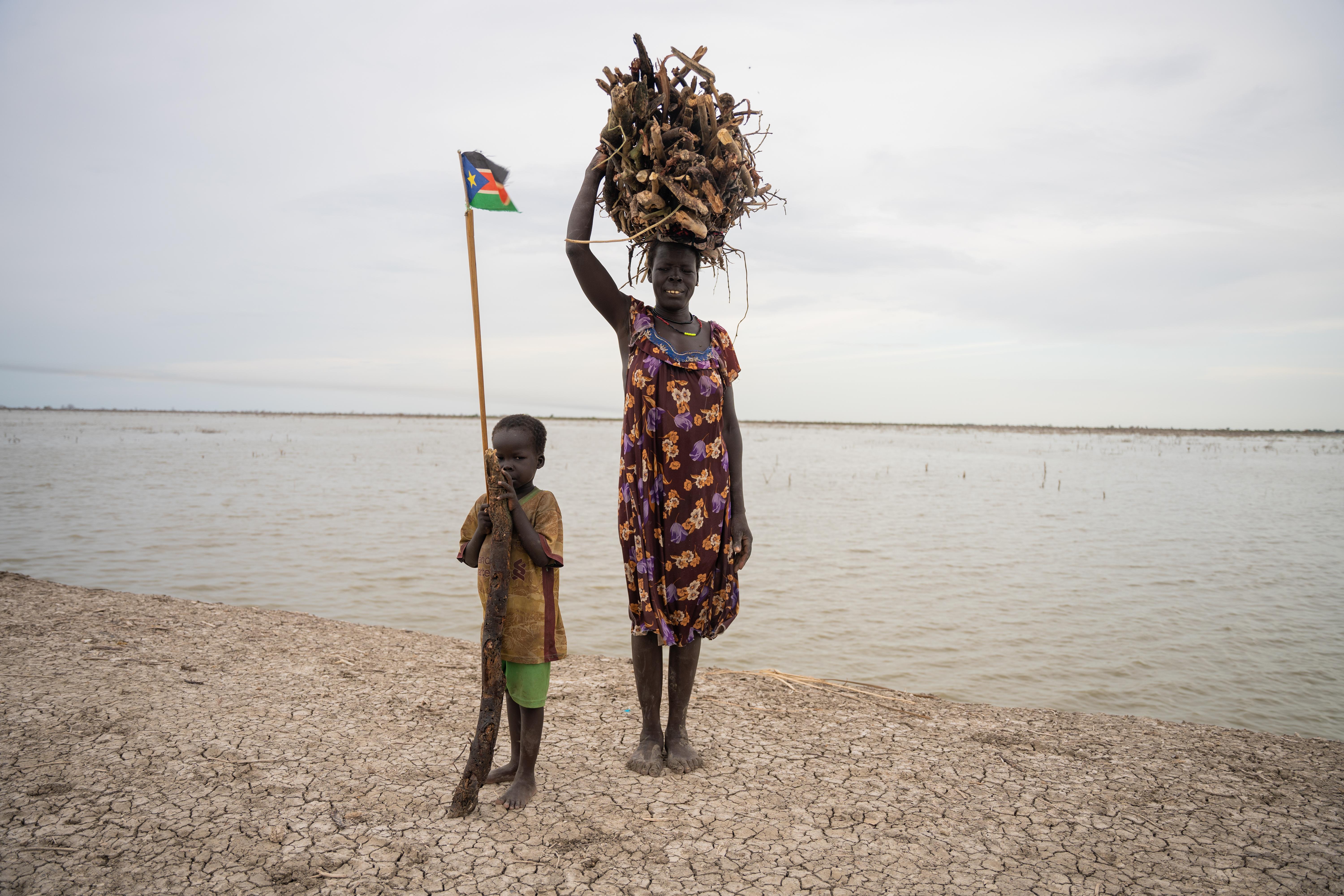 Roda Nefazal Mnot, carrying the wood she collected from the floodwaters.