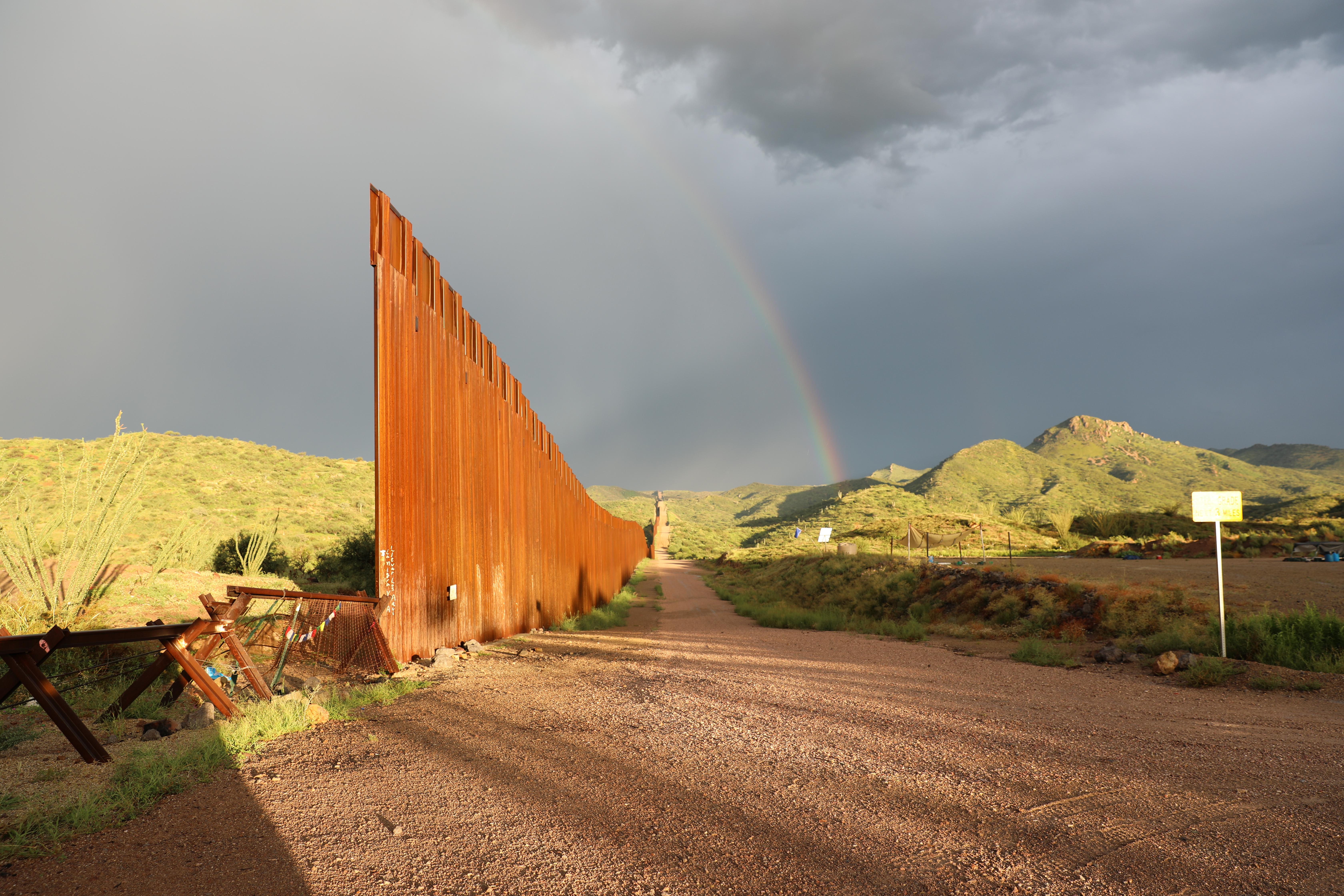 Where the United States of America and Mexico border wall ends, a chest-high fence continues to mark the border. 