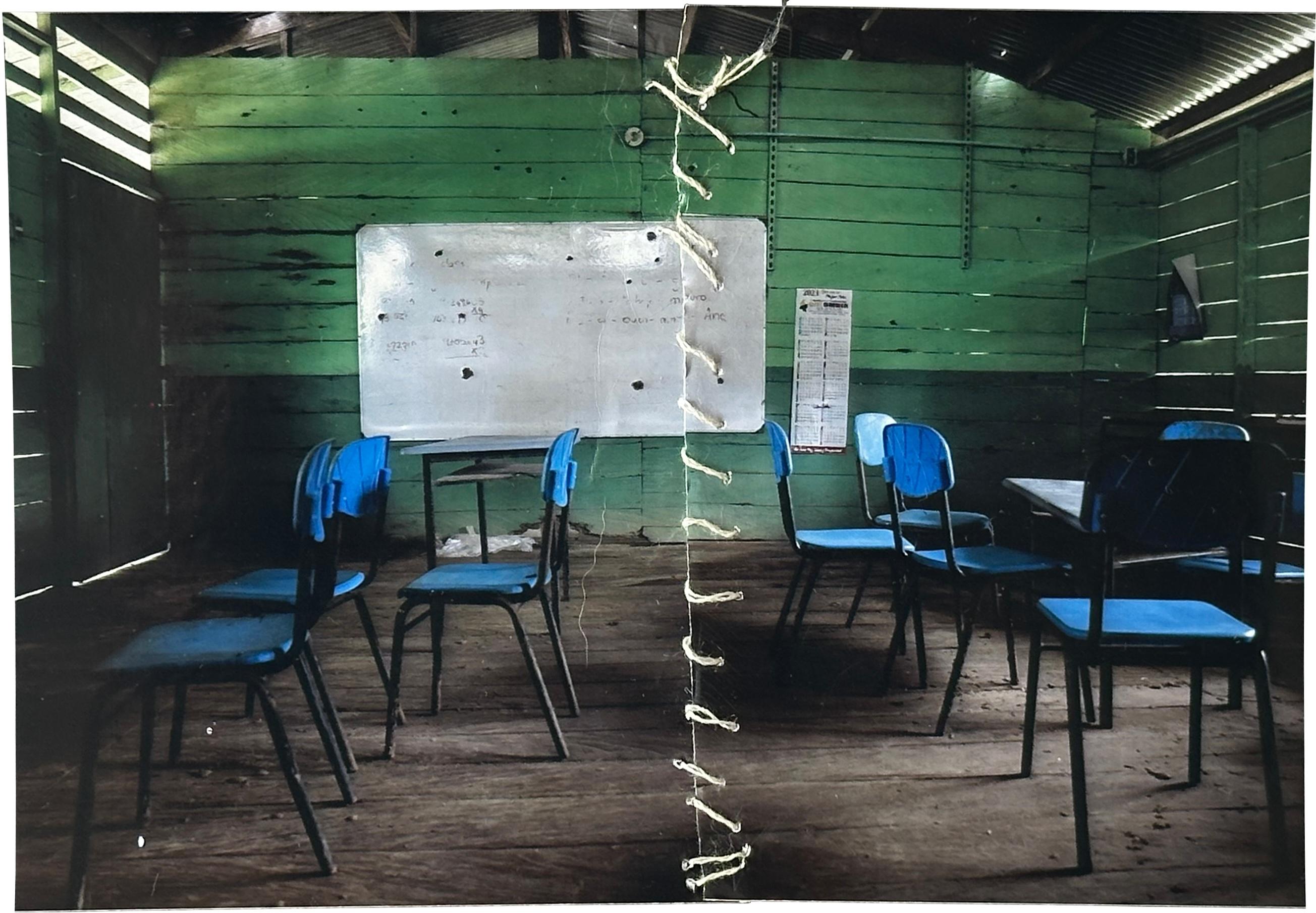 Margarita Rojas Mena, in Mojaudó, stitched up a photograph of the community school that was hit by bullets during an armed confrontation.