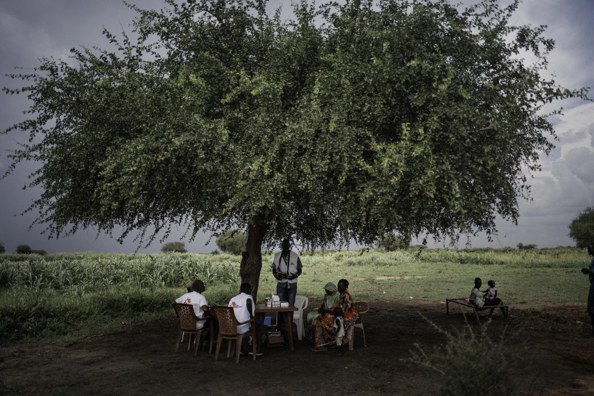 MSF team provides medical consultations to people at a temporary health post set up under a tree in Khadian, Abyei 