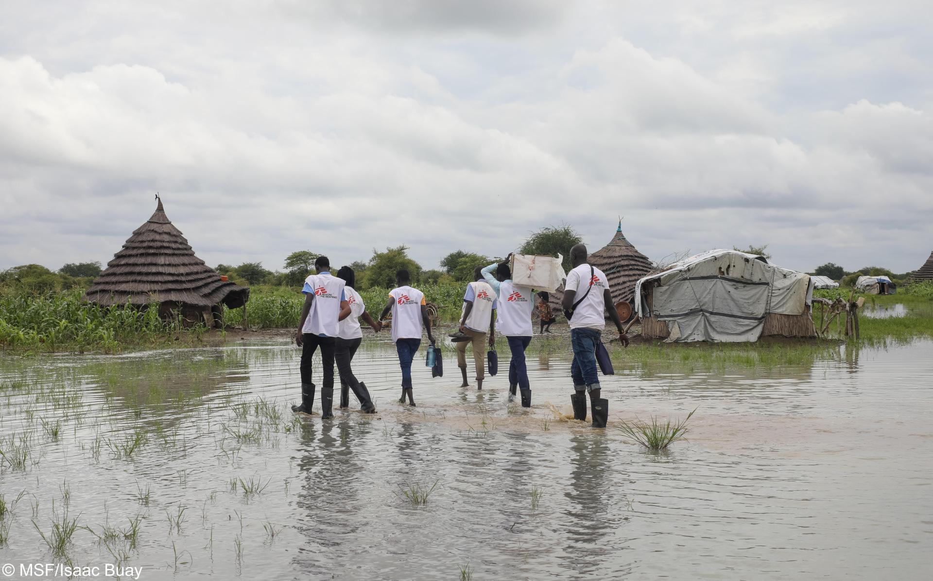 MSF teams wade through a flooded village to deliver medicine to an ICCM site in Abyei.
