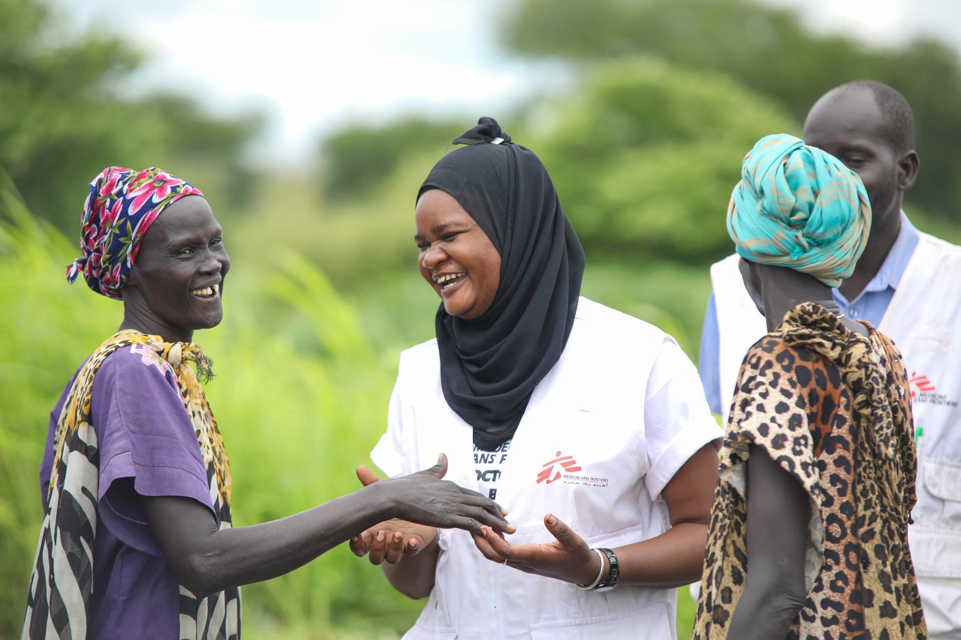 MSF Nurse Activity Manager for Abyei, Awa Abdumadou shares light moments with two community volunteers during a weekly visit to one of the 17 Integrated Community Case Management (ICCM) sites in Abyei
