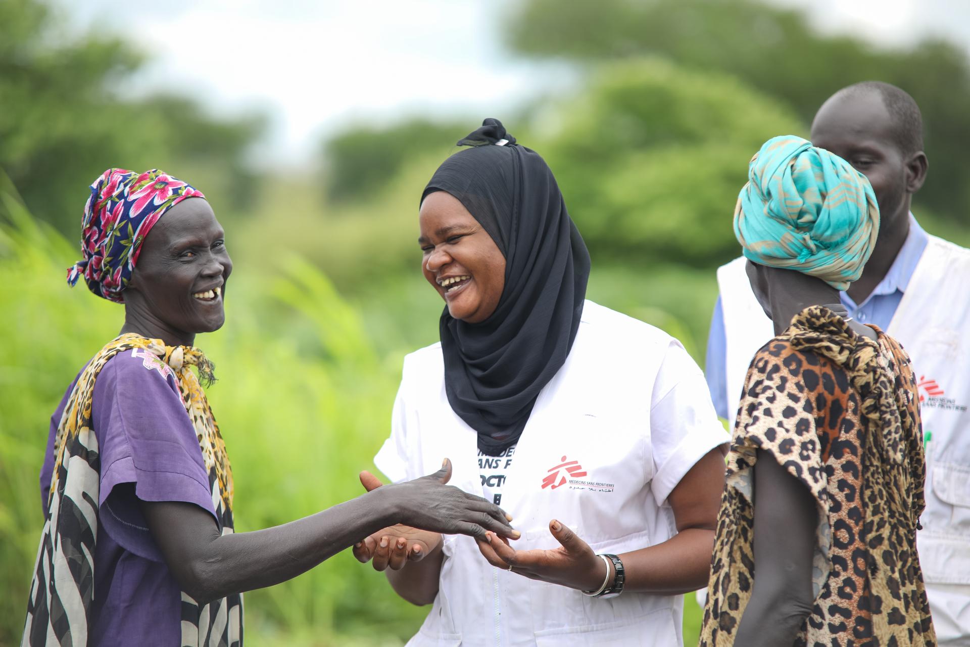 MSF Nurse Activity Manager for Abyei, Awa Abdumadou shares light moments with two community volunteers in Abyei