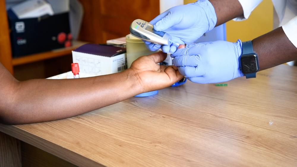 Close up of patient advocate Pamela Anyango undergoing a blood sugar test