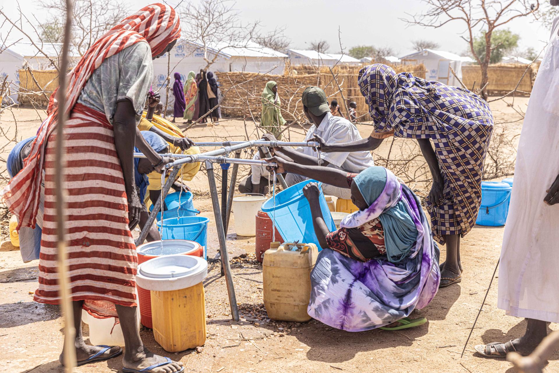 Women collecting water at a distribution point in Alacha camp, eastern Chad.